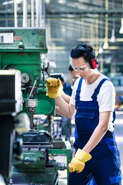 Asyalı işçi üretim fabrikasında sondaj yapıyor. — Stok fotoğraf