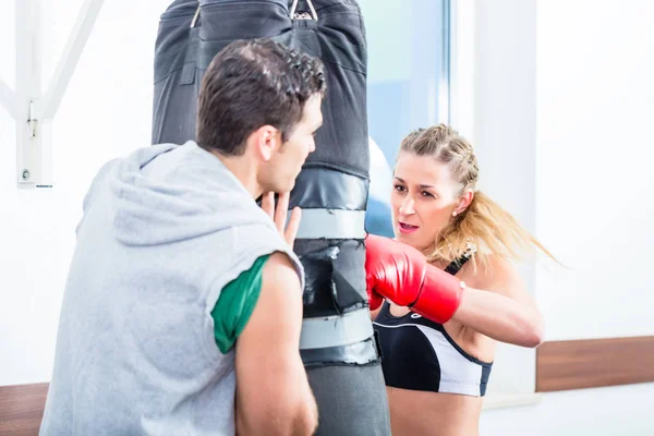 Młoda kobieta z trenerem w boks sparing — Zdjęcie stockowe