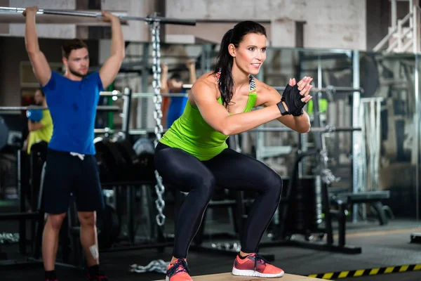 Grupo de hombres y mujeres en el gimnasio de entrenamiento funcional — Foto de Stock