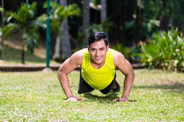 Fuerte asiático hombre haciendo deporte push-up en parque — Foto de Stock