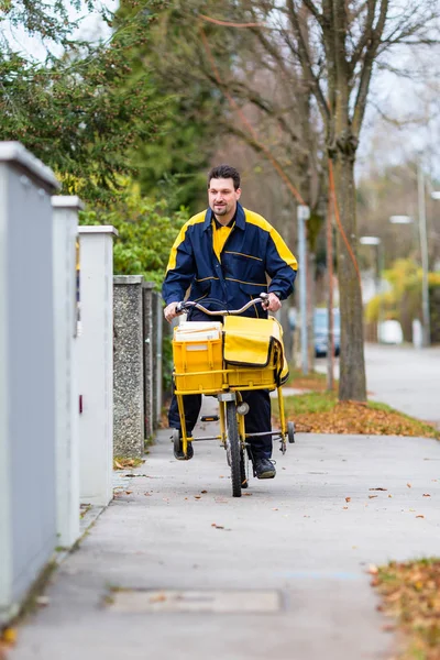 Postbode paardrijden zijn fiets lading — Stockfoto