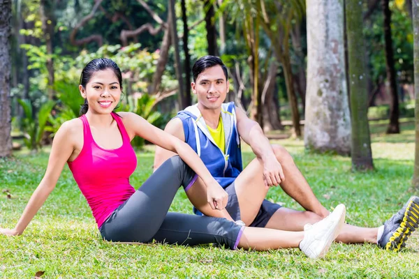 Coppia che fa sit-up nel parco tropicale asiatico — Foto Stock