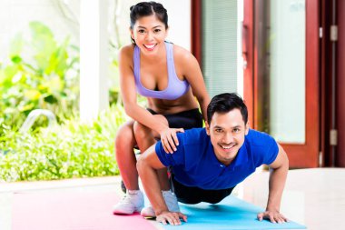 Asyalı kadın adam push-up ile yardım