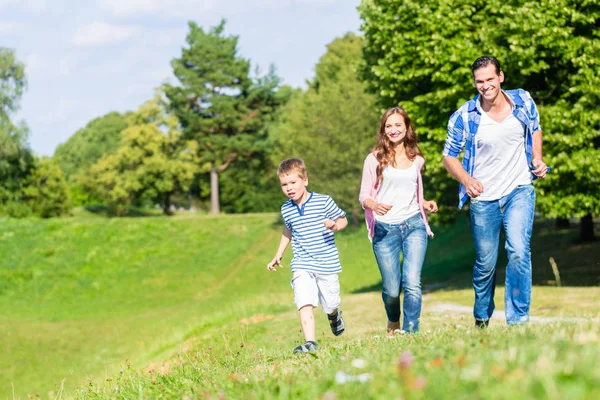 Famiglia che corre sul prato — Foto Stock