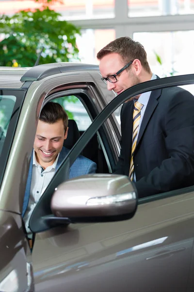 Customer buying new car in auto dealership — Stock Photo, Image