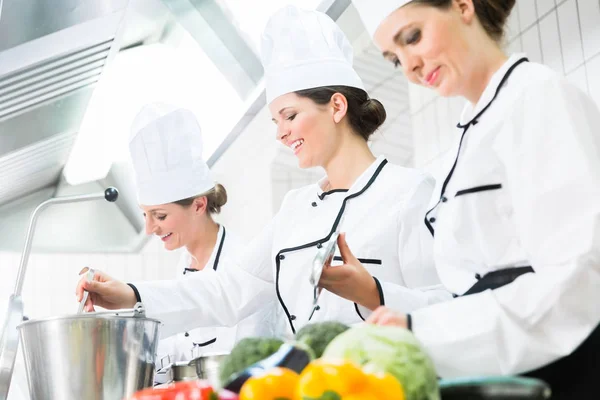 Köche bereiten Mahlzeiten in gewerblicher Küche zu — Stockfoto