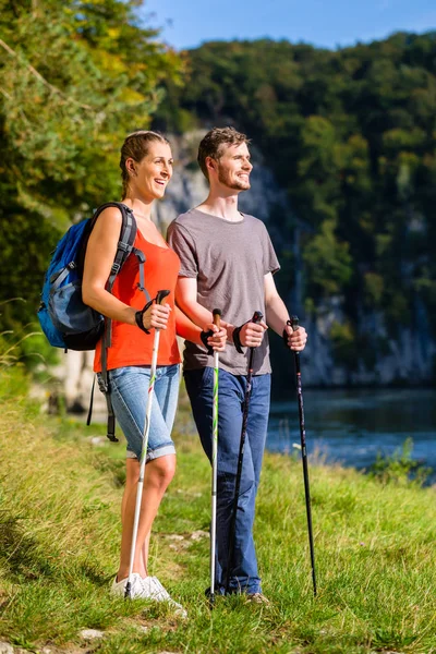 Muž a žena pěší turistiku na řece v létě — Stock fotografie