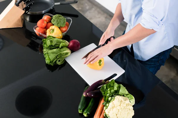 Чоловік ріже овочі на своїй кухні — стокове фото