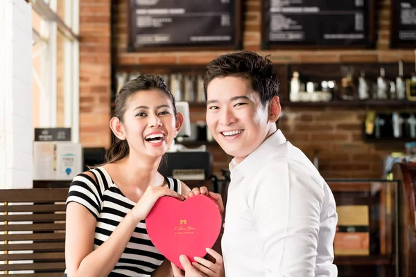 Азіатська пара займається Дата в кафе з червоне серце — стокове фото