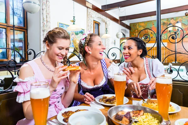 Women in Bavarian restaurant eating food — Stock Photo, Image