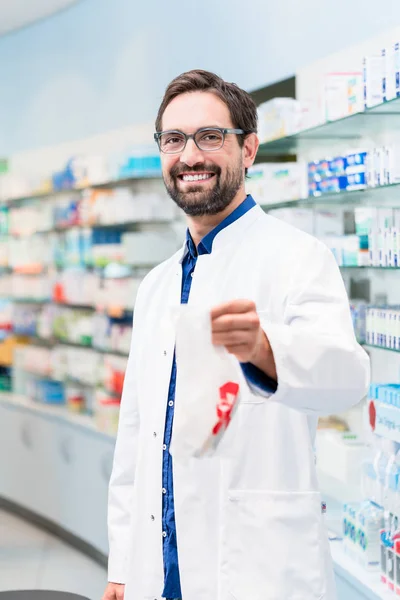 Farmacêutico na farmácia que vende produtos farmacêuticos — Fotografia de Stock