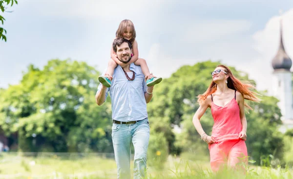 Familia caminando en el prado teniendo paseo — Foto de Stock