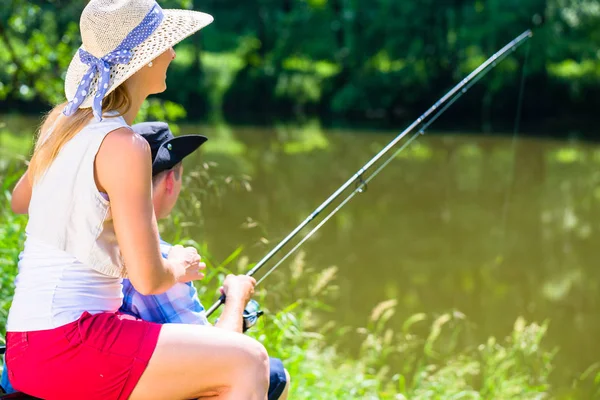 Hombre y mujer pescando con ángulo juntos en la orilla del río —  Fotos de Stock