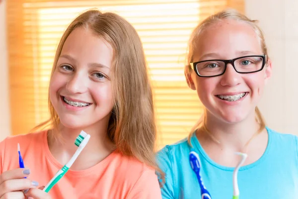 Två tjejer med dental trotjänare tandborstning — Stockfoto