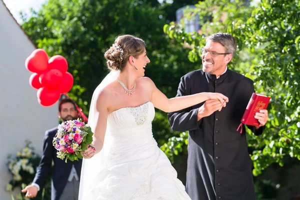 Bruden som springer iväg med präst — Stockfoto