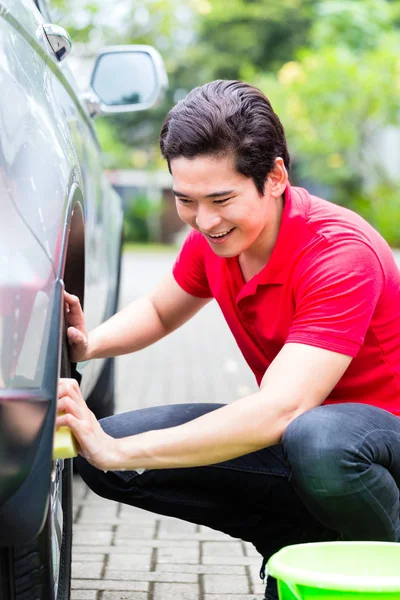 Asian man cleaning car rims — Stock Photo, Image