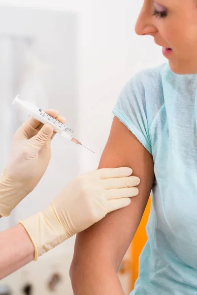 Жінка у лікаря отримує вакцинаційний шприц — стокове фото