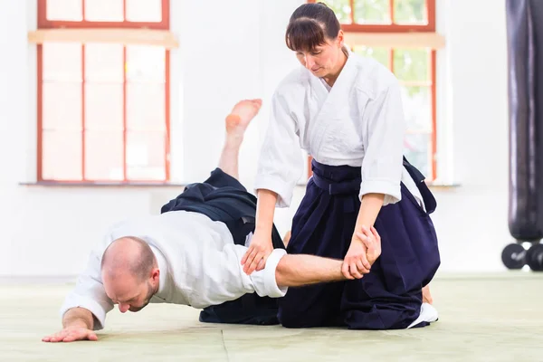 Uomo e donna che combattono alla scuola di arti marziali Aikido — Foto Stock