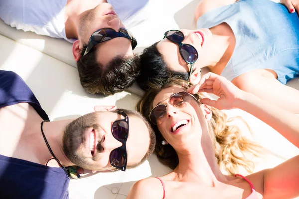 Friends lying in sand on beach — Stock Photo, Image