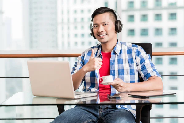 Junge asiatische Mann im Büro mit Kaffee geben Daumen nach oben Zeichen — Stockfoto