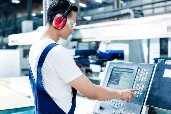 Arbeiter gibt Daten in CNC-Maschine in Fabrik ein — Stockfoto