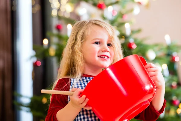 Mädchen backt Plätzchen vor dem Weihnachtsbaum — Stockfoto