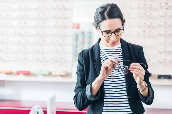 Frau nimmt Brille aus dem Regal — Stockfoto