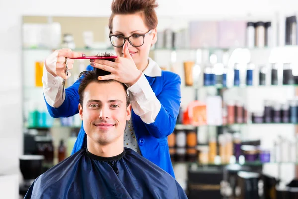 Hairdresser cutting man hair in barbershop — Stock Photo, Image