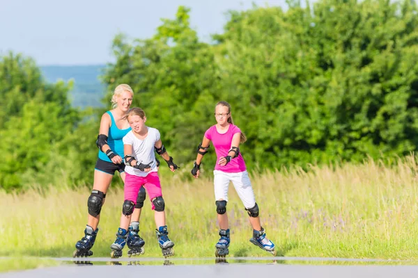 Patines familia con patines en carril de campo — Foto de Stock