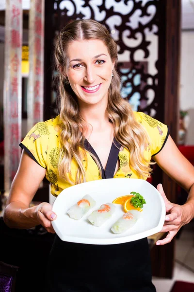 Waitress with sushi in restaurant — Stock Photo, Image