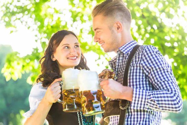 Duitse paar in klederdracht bier drinken — Stockfoto