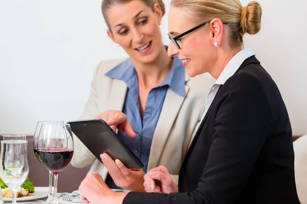 Due uomini d'affari con tablet mangiare pranzo — Foto Stock