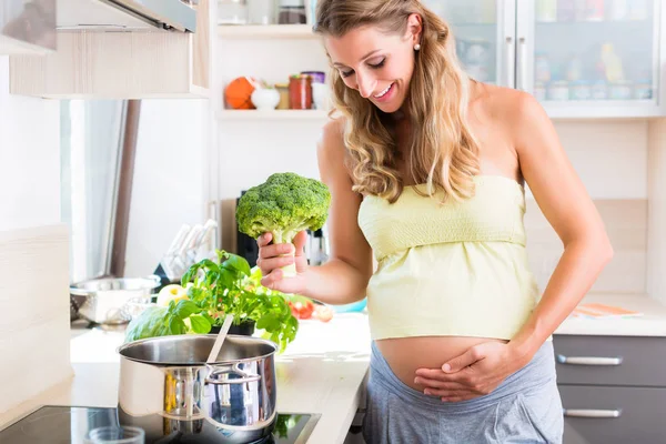 Mujer embarazada comiendo verduras saludables mostrando —  Fotos de Stock