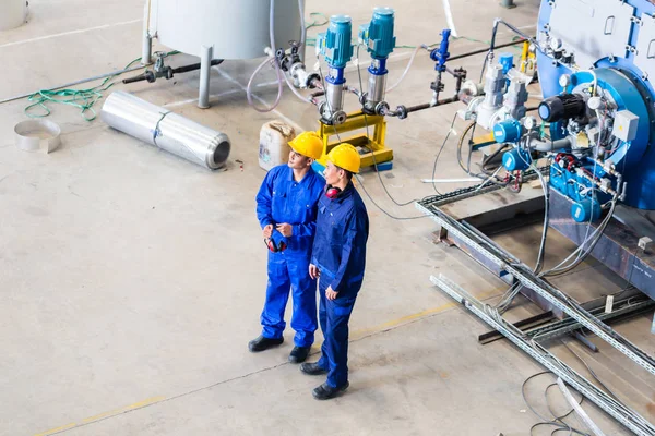 Due lavoratori in fabbrica industriale discutono — Foto Stock