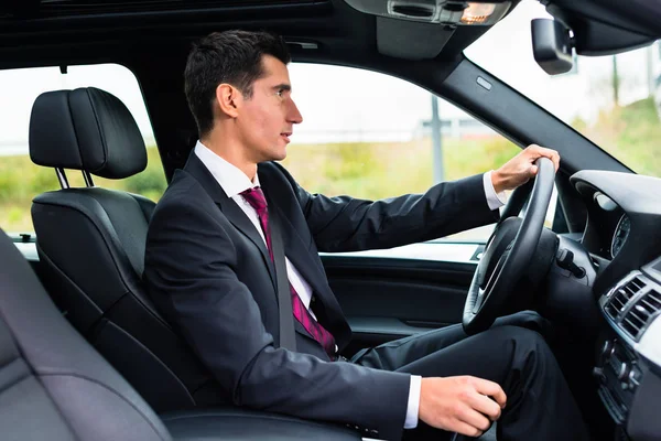 Uomo che guida in macchina in abiti da lavoro — Foto Stock