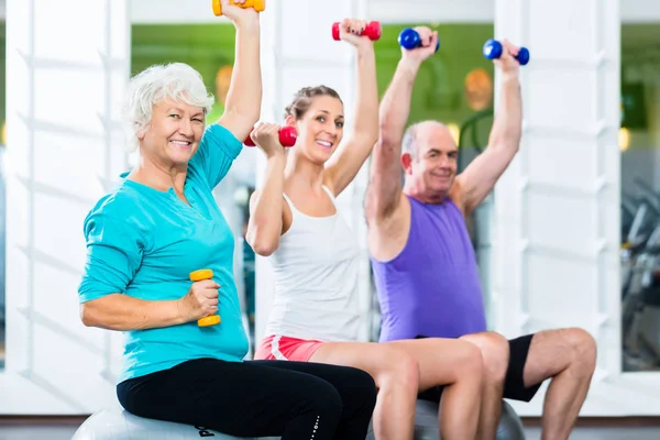 Anziani con allenatore in palestra a sollevamento pesi sportivi — Foto Stock