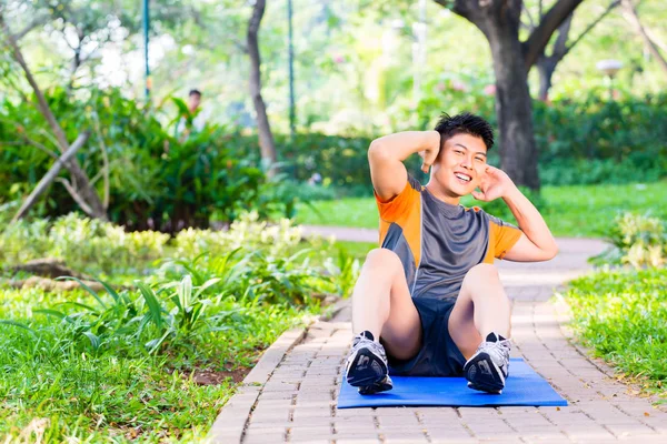 亚洲人做仰卧起坐健身培训 — 图库照片