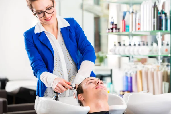 Frisören tvättar man håret i barbershop — Stockfoto