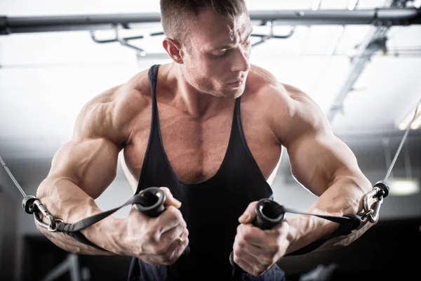 Bodybuilder doing butterfly on cable pull — Stock Photo, Image