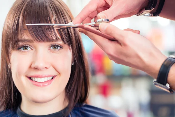 Hairdresser cutting woman bangs hair — Stock Photo, Image