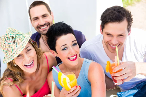 Gruppo di amici che bevono cocktail al bar sulla spiaggia — Foto Stock