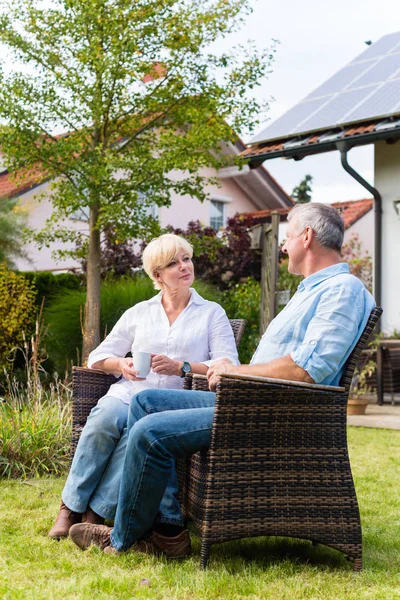 Äldre man och kvinna som sitter framför huset — Stockfoto