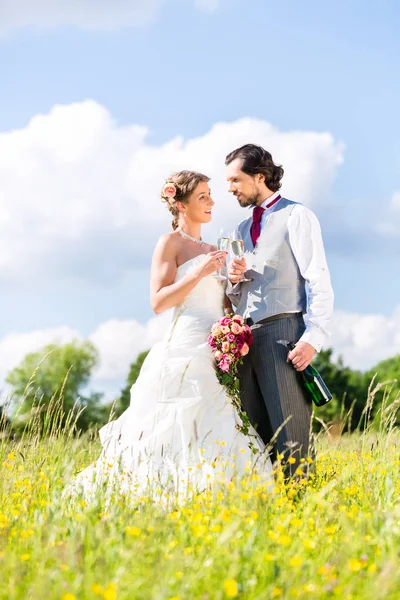 Coppia di sposi festeggiare il giorno del matrimonio con champagne — Foto Stock