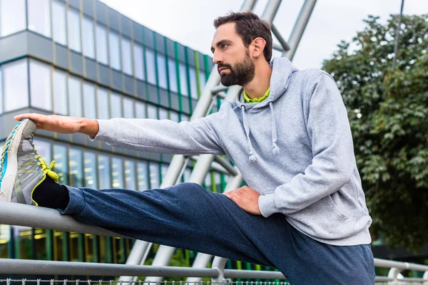 Hombre estirándose haciendo deporte — Foto de Stock