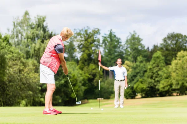 Frau übt mit Golfprofi — Stockfoto