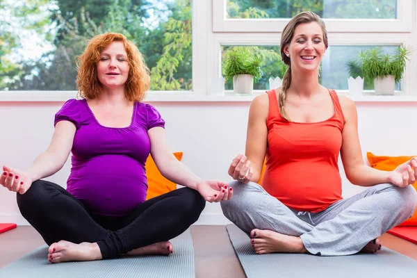 Dos mujeres avanzadas en el embarazo meditan durante la clase prenatal — Foto de Stock