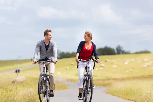 Couple having sea coast bicycle tour at levee — Stock Photo, Image