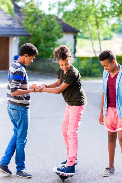 Drei Kinder spielen zusammen mit dem Brett — Stockfoto