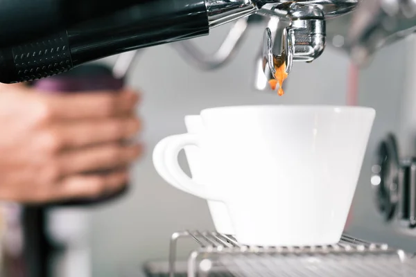 Barista bereitet Kaffee mit Portafiltermaschine zu — Stockfoto