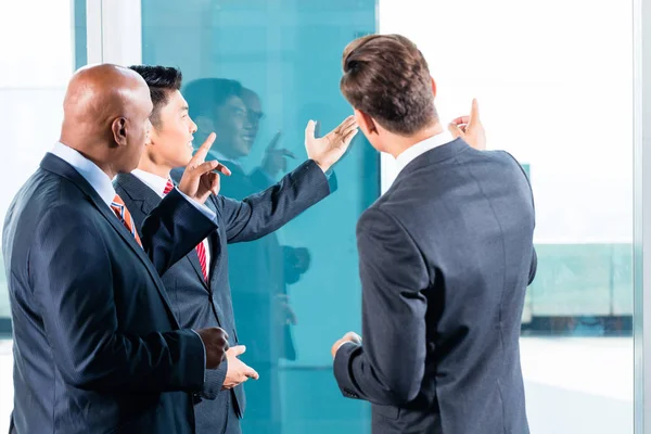 Gemischtes asiatisches Wirtschaftsteam diskutiert Projekt — Stockfoto